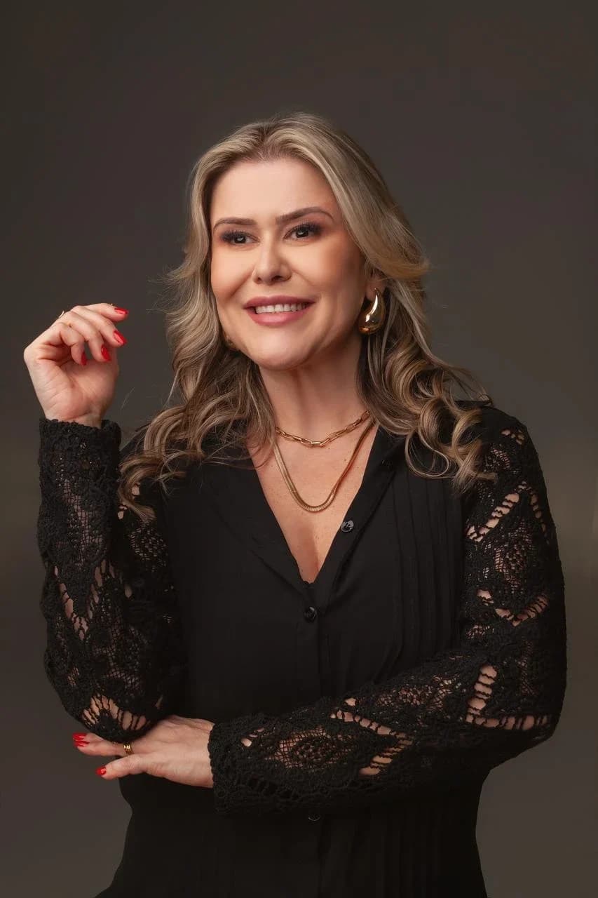 Dra. Gláucia Messa sorrindo, de blusa preta com mangas de renda